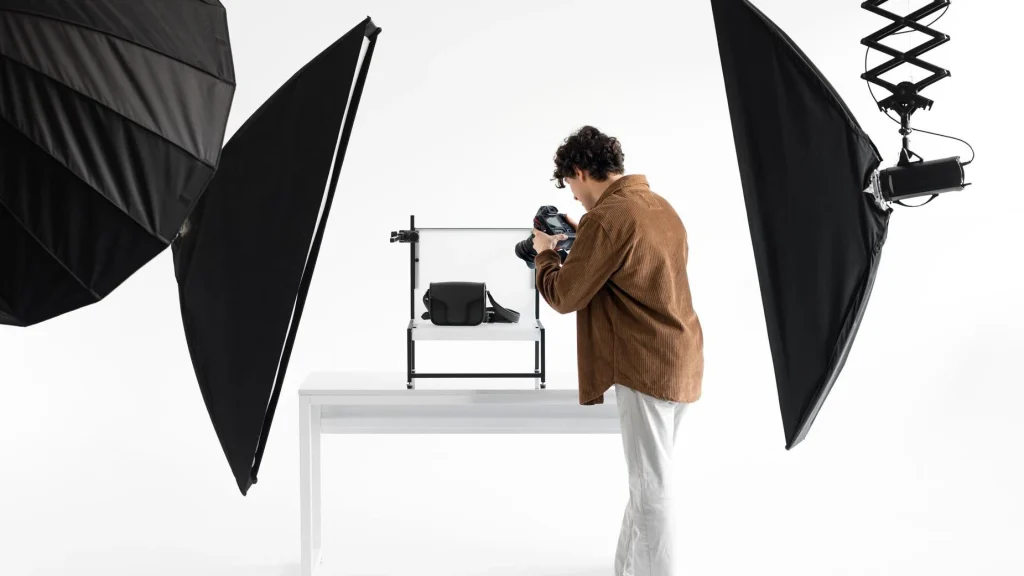 Photographer capturing a leather bag using twin softbox lighting in studio
