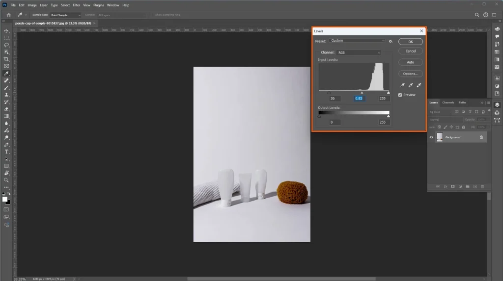 Photoshop Levels panel adjusting shadows, midtones, and highlights in a product image