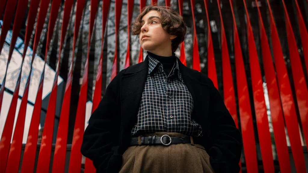 High fashion model posing in front of a dramatic red architectural background