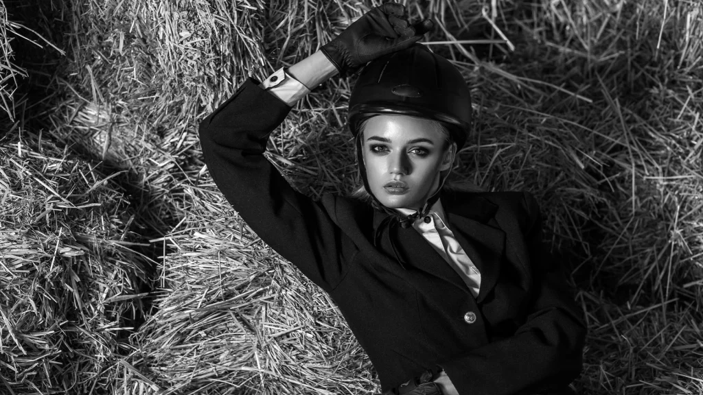 Black and white historical fashion portrait of a model in equestrian clothing