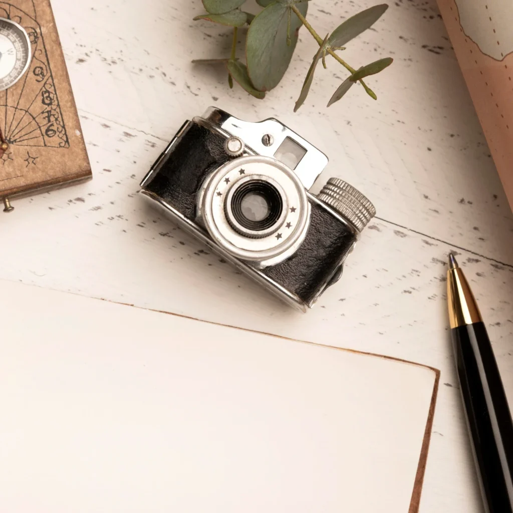 Vintage camera with notebook and stationery arranged in a nostalgic flat lay composition.
