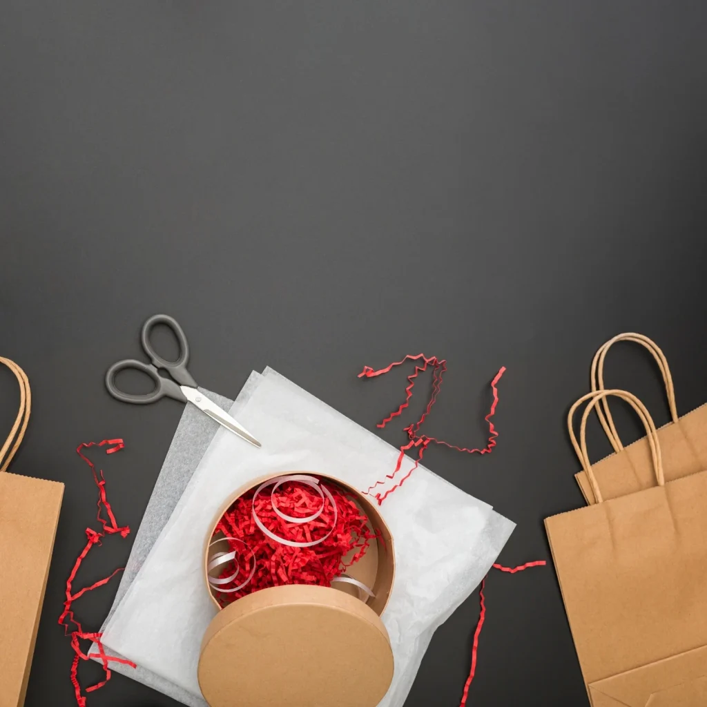 Product packaging and unboxing setup with kraft boxes, tissue paper, and gift filler.