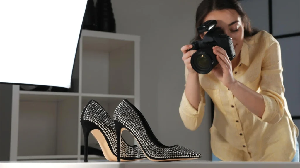 Photographer capturing product shots of studded high-heel shoes on a table