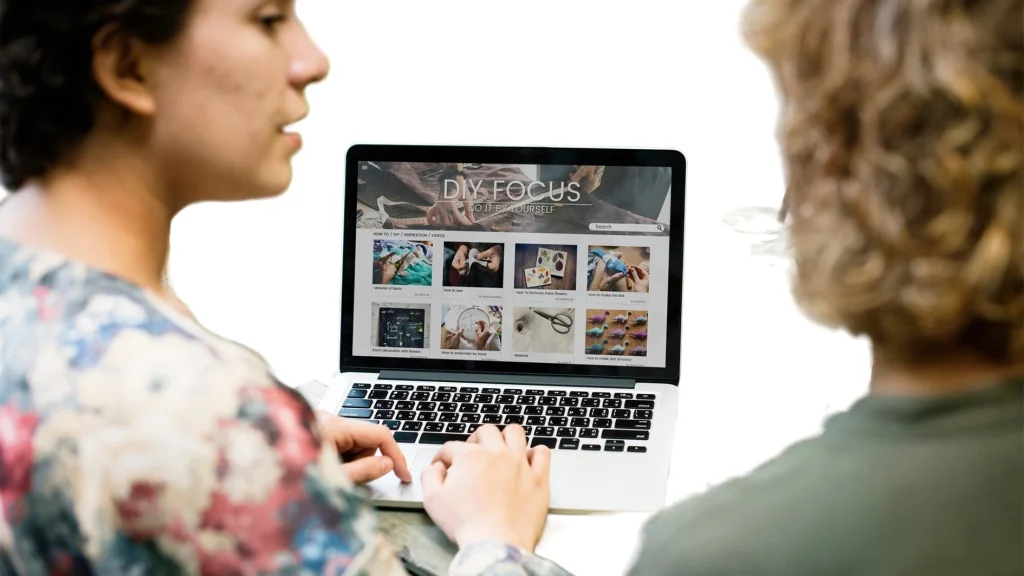 Two people browsing product photos on a laptop, representing how customers notice ecommerce photo editing mistakes