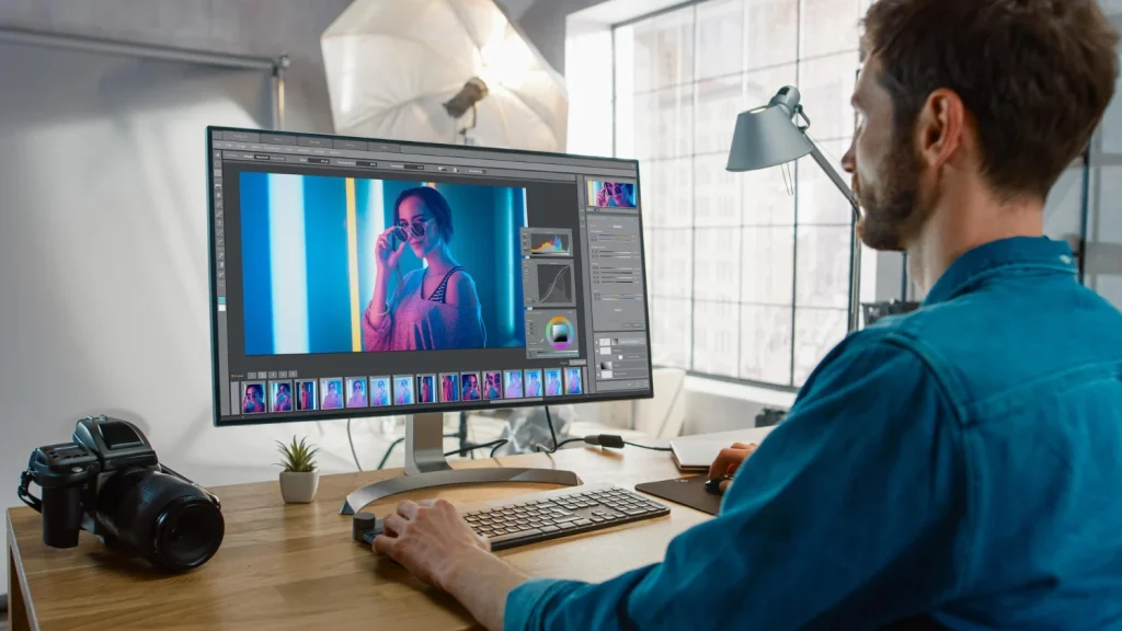 Photo editor color-correcting a portrait on screen, showing fast turnaround and scalable outsourced editing