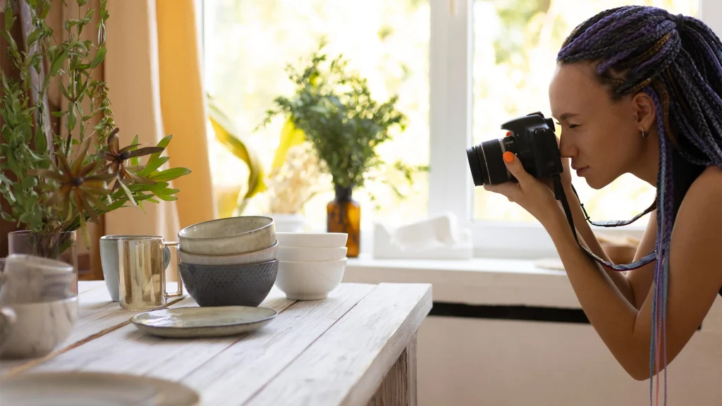Photographer using natural window light for product photography lighting of ceramic bowls and tableware