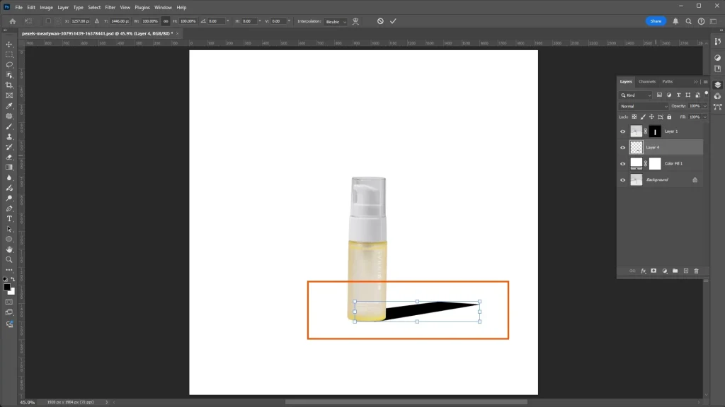 Solid black shadow silhouette shape being positioned in Photoshop to create a realistic shadow effect.
