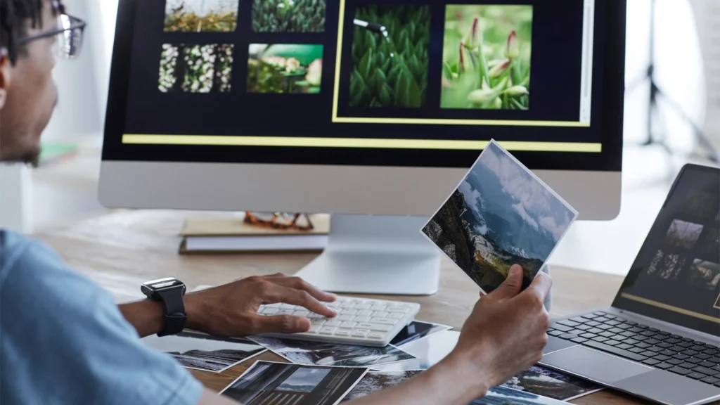 Editor sorting printed and digital photos, illustrating in-house team workload as catalog volume grows