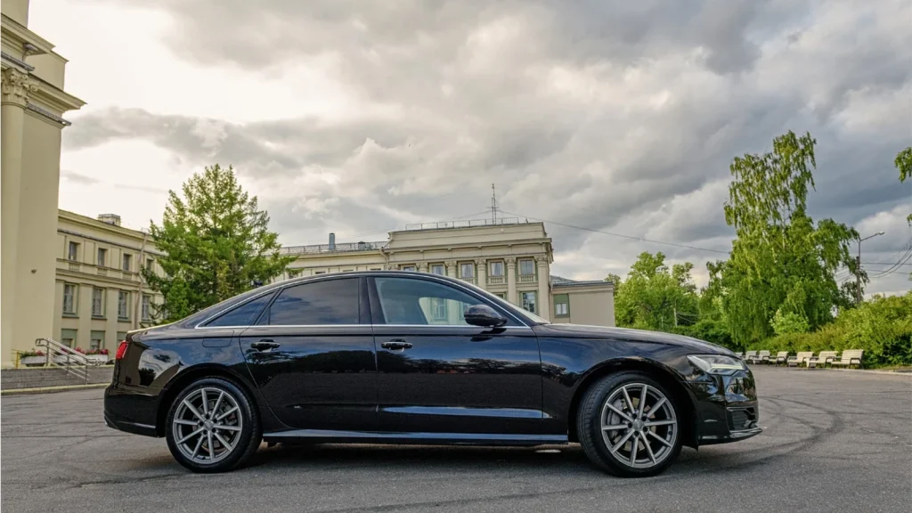 Black luxury car photographed in front of historic architecture
