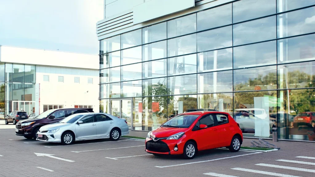 Red car photographed outside a modern office building for car photography