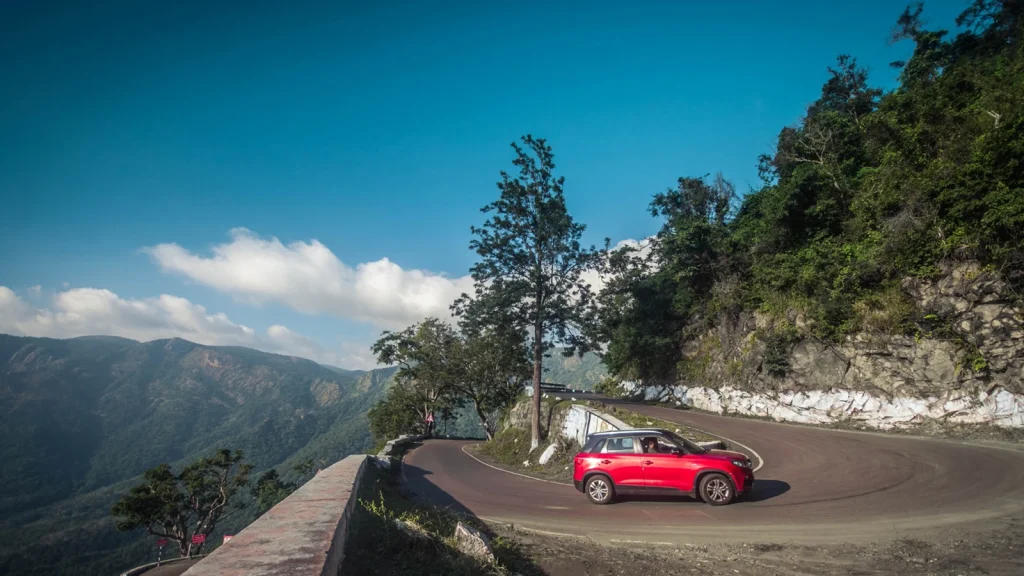 Red SUV photographed on a scenic mountain road for car photography