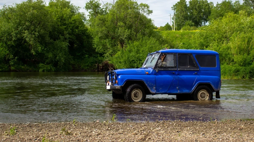 Blue off-road vehicle photographed at a waterfront location for car photography