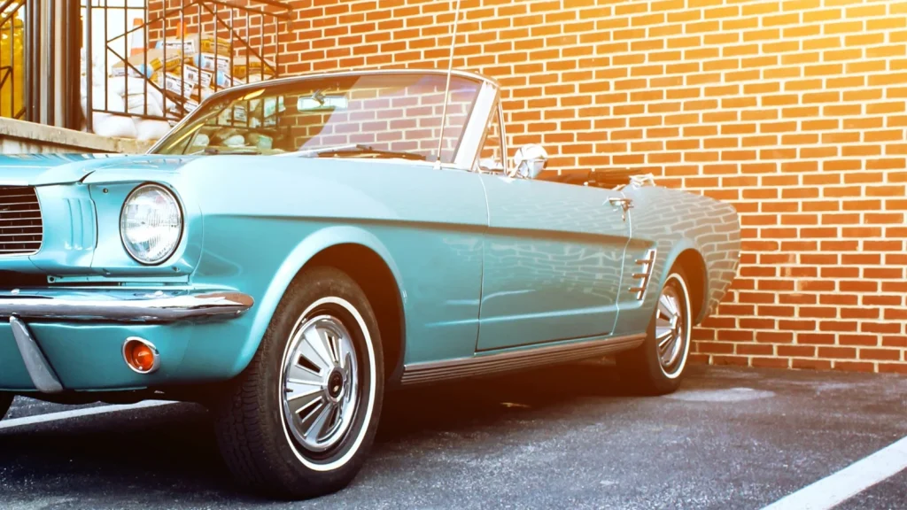 Classic car photographed beside an old brick building