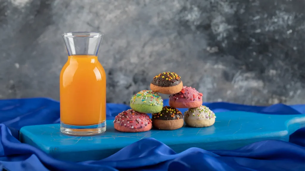 Food and beverage photography featuring colorful donuts and a glass of orange juice