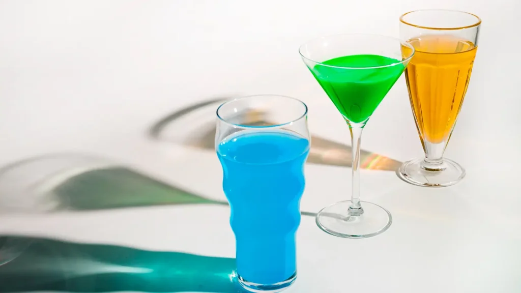 Glass and liquid product photography featuring three colorful drinks on a white surface