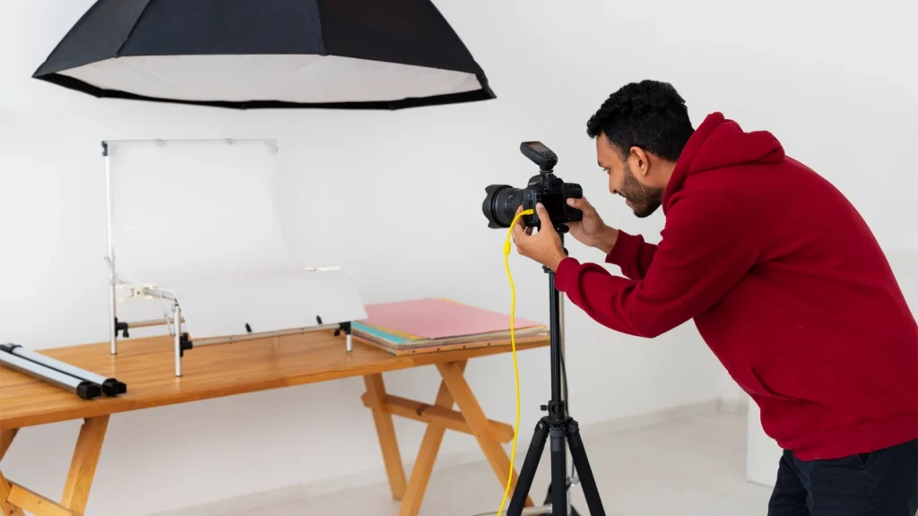 Home product photography setup with camera, tripod, lighting, and white backdrop