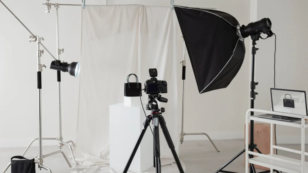 Product photography studio setup with camera, tripod, backdrop, and softbox lighting