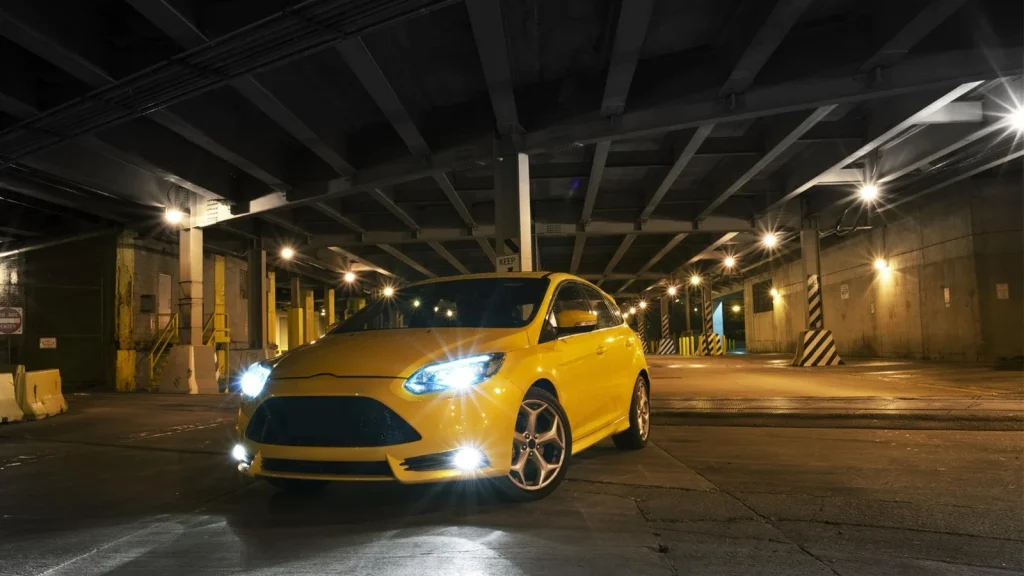 Yellow car photographed inside a parking garage at night
