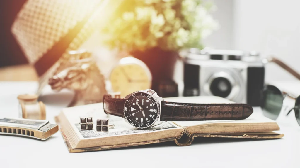 Rose gold chronograph watch with white dial photographed beside a laptop showing controlled lighting and reflections