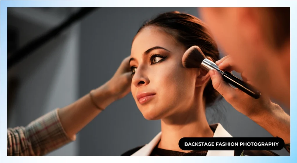 Makeup artist applying blush to a model while a stylist adjusts her hair, backstage fashion photography