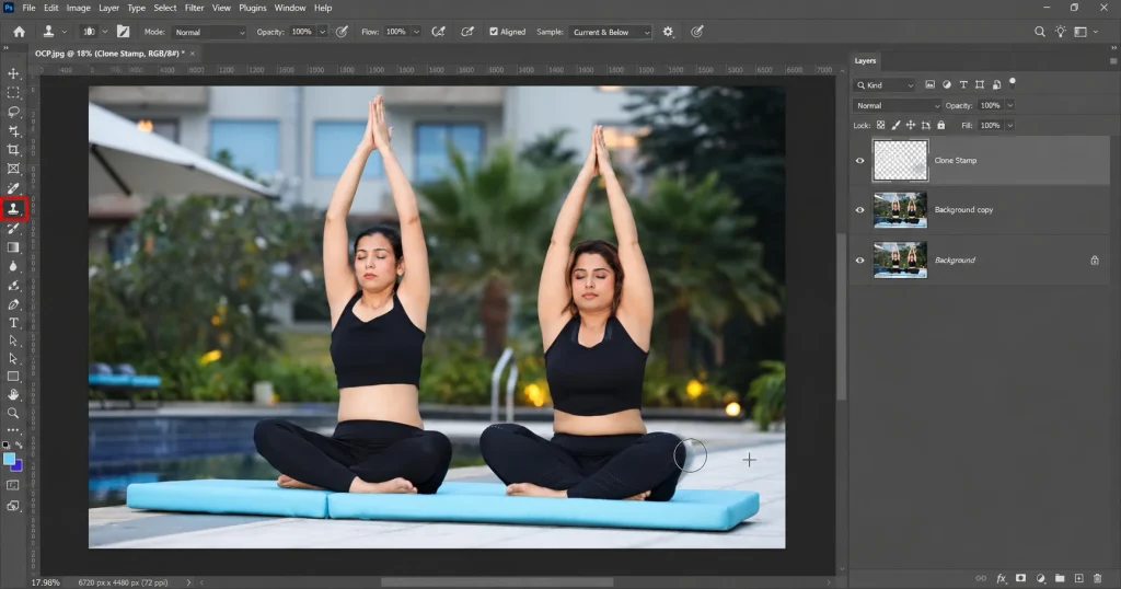 Photoshop Clone Stamp tool with brush circle and source crosshair on the photo