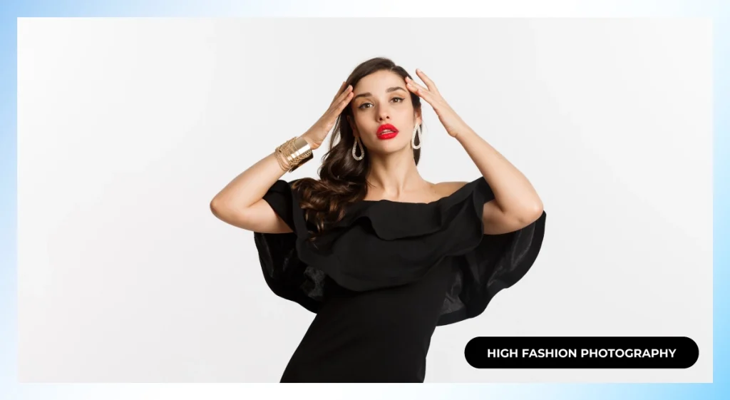 Model in a black off-shoulder ruffle dress with red lipstick and gold cuff posing with hands at her head, high fashion photography
